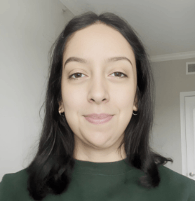 A woman with middle-parted dark hair wearing a green top smiling gently at the camera, giving her reviews about home repairs provided by Icarus services